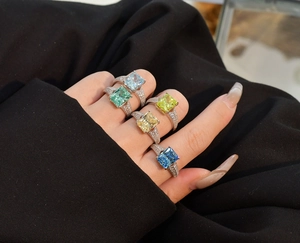 Nahaufnahme von bunten Edelsteinringen im Radiantschliff mit Pavé-Diamanten