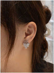 Detail of S925 silver stud earrings with pear-cut cubic zirconia on a model's ear