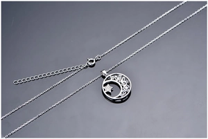 Macro shot of silver crescent moon and sparkling star pendant on fine necklace chain