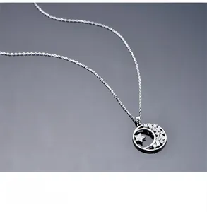 Detailed macro view of S925 sterling silver star and moon pendant with cubic zirconia stones