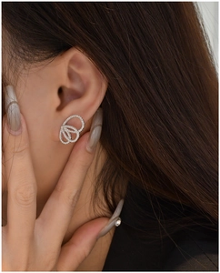 Gros plan de boucles d'oreilles ajourées en couches avec argenture et diamants blancs