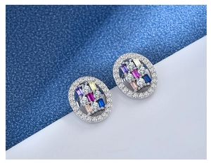 Macro shot of oval S925 silver earrings with colorful gemstones and zircon inlay detail
