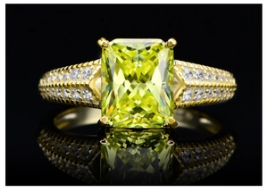 Macro detail of radiant cut yellow diamond ring with micro-paved band and mirror reflection