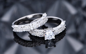 Macro shot of 925 silver ring set with six-prong center diamond and channel-set band