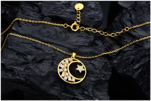 Macro shot of gold crescent moon and star pendant with sparkling cubic zirconia inlay