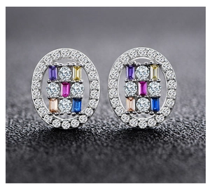 Macro shot of oval silver stud earrings featuring colorful gemstones and pave zircon trim