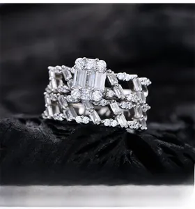 Detailed shot of layered S925 silver rings with baguette cubic zirconia on dark stone