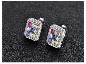 Macro shot of rectangular silver stud earrings with colorful cubic zirconia and micro-pave setting