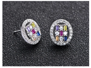 Close-up of S925 silver oval stud earrings with colorful gemstones on black leather