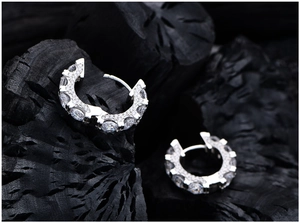 Detail view of S925 sterling silver hoop earrings with pave diamonds on dark texture
