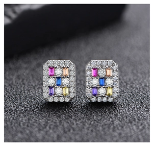 Macro shot of rectangular silver stud earrings with colorful zircons and micro-pave setting