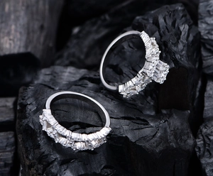 Macro shot of silver S925 rings with square cubic zirconia on a black textured background
