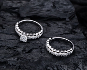 Macro view of two S925 silver rings featuring lace mesh design and micro-pave diamonds