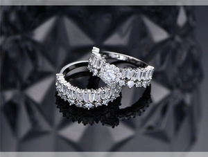 Macro shot of 925 silver halo rings with baguette and round zircon stones on black background