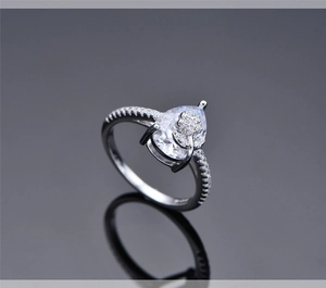 Detailed view of pear-cut gemstone ring with floral accents and micro-pave silver band