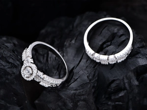 Detailed macro view of S925 silver wedding rings with oval zircon on charcoal background