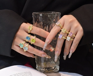 Macro detail of multi-colored ice flower cut gemstone rings on model's hand