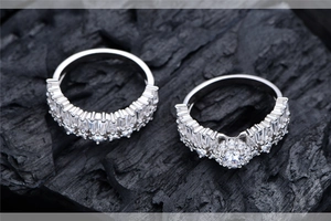 Macro view of two S925 sterling silver snowflake rings with sparkling cubic zirconia on charcoal