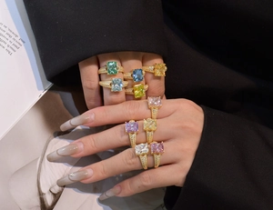 Group of colorful 5.6ct ice-cut rings on hand with gold band and pave-set zircons