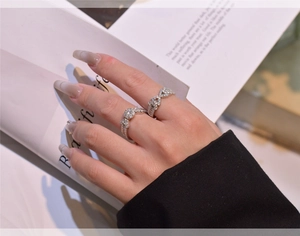 Detail showing stacked S925 silver rings with round main stone and bow design elements
