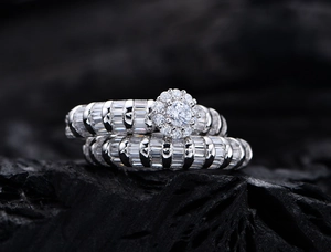 Macro shot of 925 silver double ring set with zircon pavé and flower cluster on charcoal