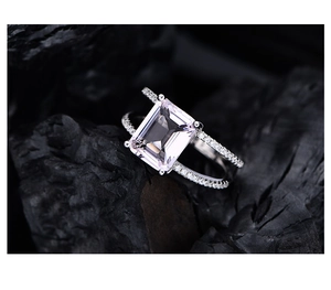 Macro shot of rectangular emerald-cut pink stone set in micro-pave S925 silver ring