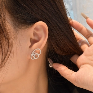 Boucles d'oreilles argentées à triple anneau entrelacé serties de zircons brillants