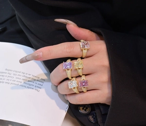 Close-up of five radiant square cut gemstones in colorful hues with pavé-set bands