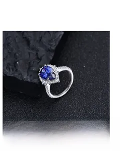 Macro shot of a heart-cut blue gemstone ring with micro-pave diamonds on black stone