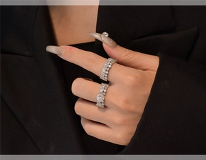 Detail of stacked S925 silver rings with snowflake zircon inlay on a model hand