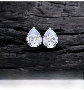 Macro view of pear-shaped silver studs with floral diamond inlay and platinum texture