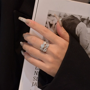Silver multi-layer S925 ring with zircon stones shown on a model hand with magazine