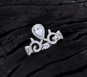 Macro detail of crown ring with pear-cut main stone and micro-paved white zircons