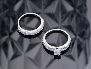 Detailed view of silver stacking ring set featuring square-cut zircon stones on black background