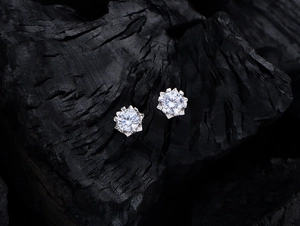 Macro shot of 925 sterling silver snowflake stud earrings with sparkling round diamonds