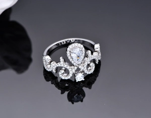 Macro shot of silver tiara ring with micro-pave diamonds and pear-cut center stone