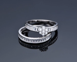 Detail of S925 silver two-piece ring set with baguette-cut zircons and flower cluster setting