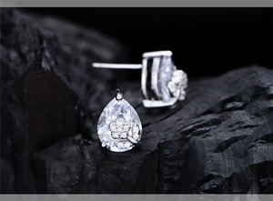 Detail of pear-shaped cubic zirconia stud earrings with silver floral micro-pave setting