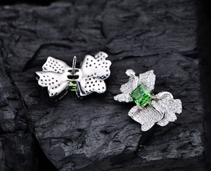 Dettaglio di orecchini a farfalla con pietre verdi e micro-pave in argento sterling 925