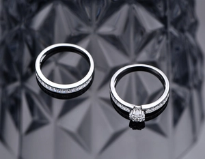 Macro shot of silver stacking ring set with round cut cubic zirconia on black background