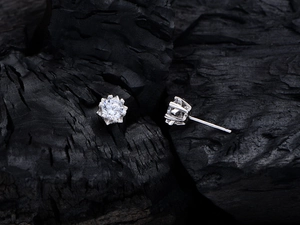 Macro shot of 925 sterling silver snowflake stud earrings with six-prong brilliant cubic zirconia