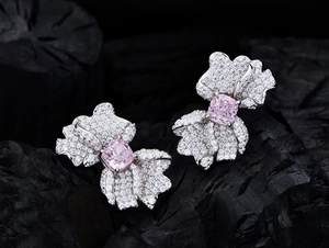 Dettaglio orecchini a farfalla con pietre quadrate rosa e pavé di cristalli luminosi