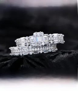Detail of 925 silver rectangular pave set wedding ring set on textured black background
