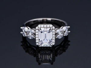 Detailed close-up of S925 stamp on emerald cut silver ring with halo design