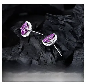 Macro view of marquise-cut purple stone earrings with a halo set on charcoal