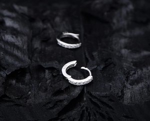 Macro shot of S925 sterling silver hoop earrings with pavé crystals and hallmark