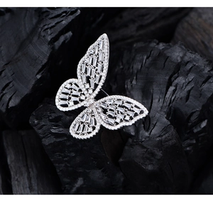 Macro shot of silver hollow butterfly ring with zircon micro-pave on textured dark stone