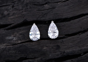 Macro shot of pear-cut high carbon diamond earrings with classic S925 silver 3-prong setting