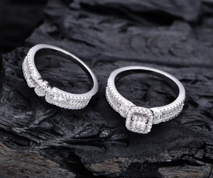 Vue macro de deux bagues en argent 925 avec zircons cubiques sur fond de bois de charbon