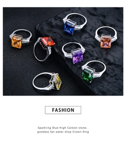 Detalle de anillos de plata 925 con piedras de colores de corte cuadrado sobre roca
